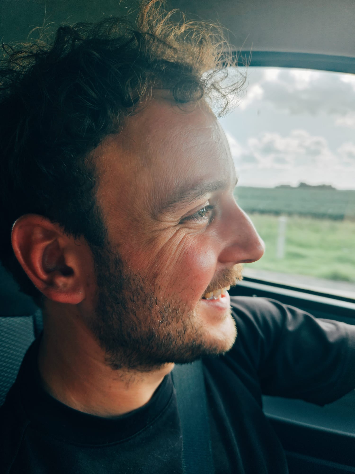 Daan laughing, looking out a car window